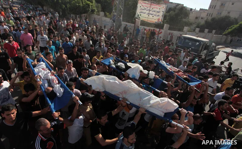 (FILES) This file photo taken on July 16, 2014 shows Palestinians carry the body of boys from the Baker family, whom medics said were killed by a shell fired by an Israeli naval gunboat, during their funeral in Gaza City...