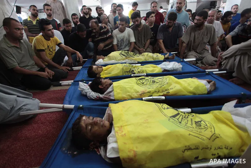 (FILES) This file photo taken on July 16, 2014 shows Palestinians mourn over the body of boys from the Baker family, whom medics said was killed with three other children from the same family by a shell fired by an Israe...