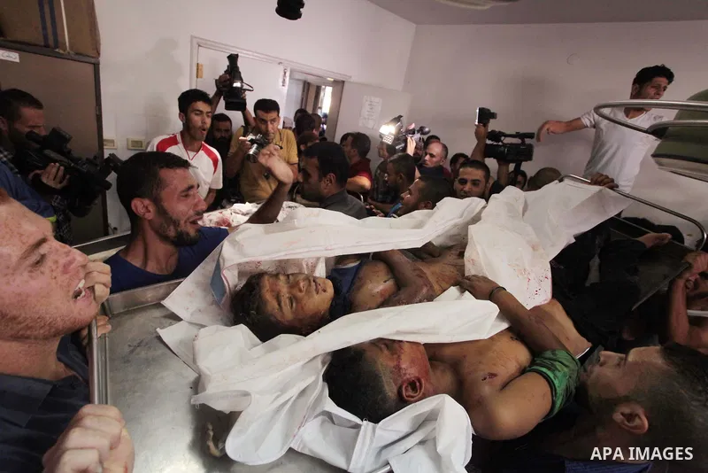 (FILES) This file photo taken on July 16, 2014 shows Palestinians carry the body of boys from the Baker family, whom medics said were killed by a shell fired by an Israeli naval gunboat, during their funeral in Gaza City...