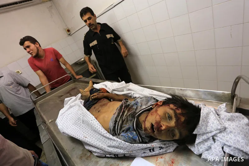 (FILES) This file photo taken on July 16, 2014 shows Palestinians mourn over the body of a boy from the Baker family, whom medics said was killed with other three children from the same family by a shell fired by an Isra...