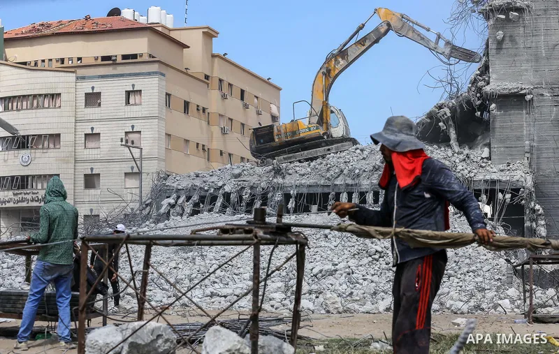 Palestinian workers remove the rubbles from el-katiba building that was damaged in an Israeli airstrike on the Gaza City, on August 14, 2018. Photo by Dawoud Abo Alkas