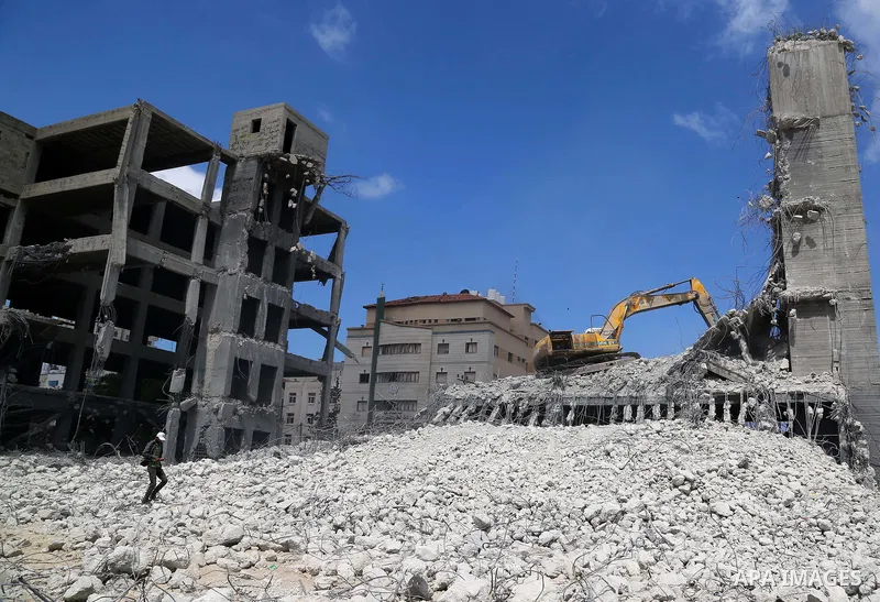 Palestinian workers remove the rubbles from el-katiba building that was damaged in an Israeli airstrike on the Gaza City, on August 14, 2018. Photo by Dawoud Abo Alkas