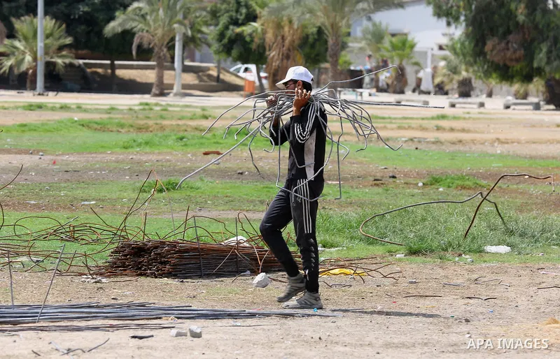 Palestinian workers remove the rubbles from el-katiba building that was damaged in an Israeli airstrike on the Gaza City, on August 14, 2018. Photo by Dawoud Abo Alkas