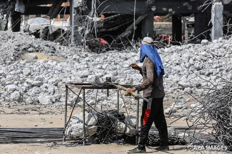 Palestinian workers remove the rubbles from el-katiba building that was damaged in an Israeli airstrike on the Gaza City, on August 14, 2018. Photo by Dawoud Abo Alkas