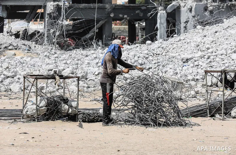 Palestinian workers remove the rubbles from el-katiba building that was damaged in an Israeli airstrike on the Gaza City, on August 14, 2018. Photo by Dawoud Abo Alkas