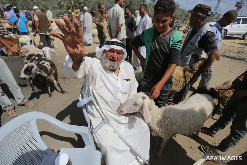 Palestinians gather at a live stock market, ahead of Eid al-Adha in Deir al-Balah, in the center of the Gaza Strip on August 14, 2018. Eid al-Adha (the Festival of Sacrifice) is celebrated throughout the Muslim world as...