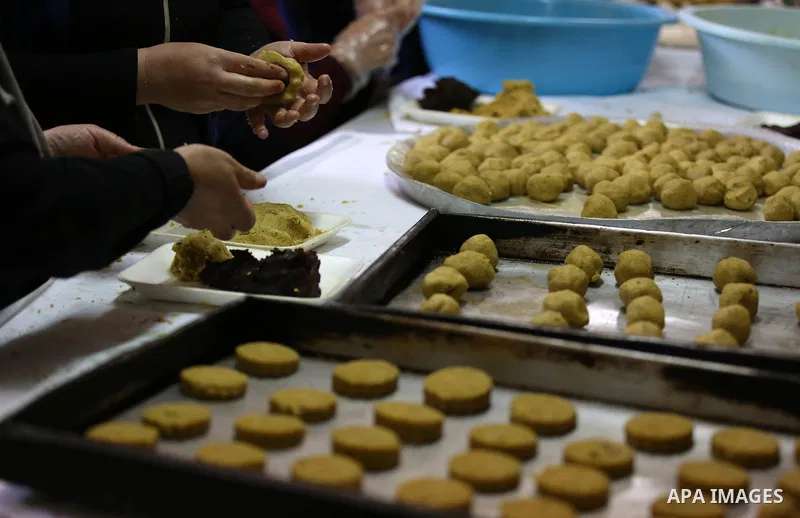 Palestinian volunteers prepare traditional date-filled mini cakes to distribute to poor families ahead of Eid al-Adha in the West Bank city of Nablus on August 15, 2018. Photo by Ayman Ameen