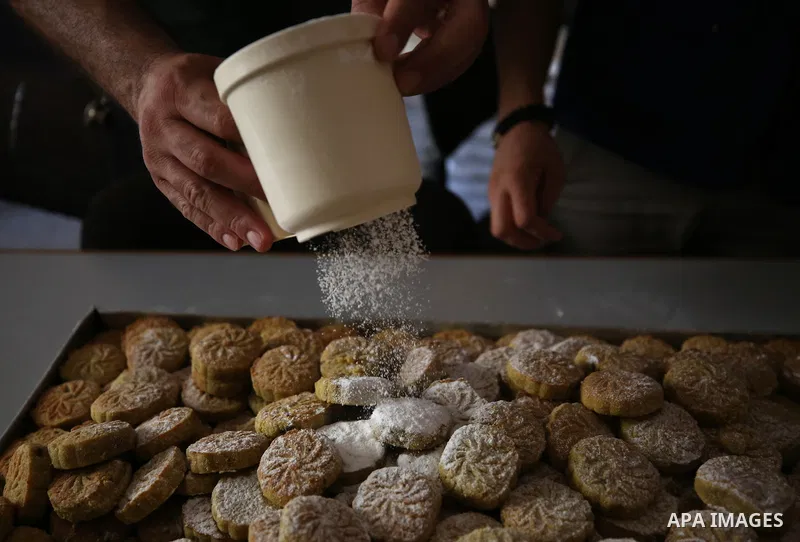 Palestinian volunteers prepare traditional date-filled mini cakes to distribute to poor families ahead of Eid al-Adha in the West Bank city of Nablus on August 15, 2018. Photo by Ayman Ameen