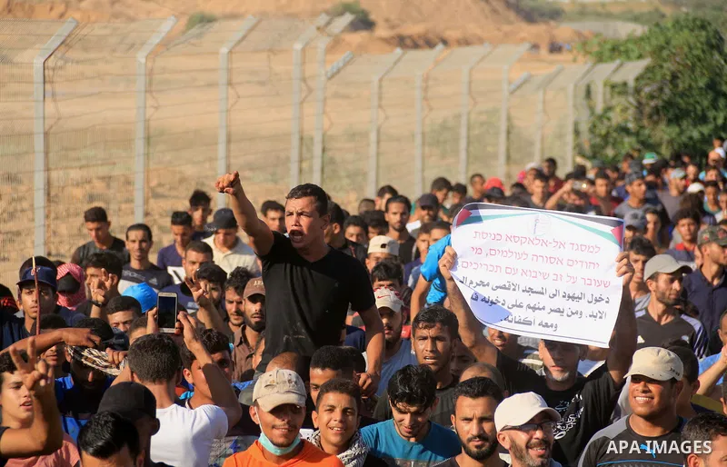 Palestinian protesters gather during clashes with Israeli troops in tents protest where Palestinians demand the right to return to their homeland at the Israel-Gaza border, in al-Bureij in the center of Gaza Strip on Aug...