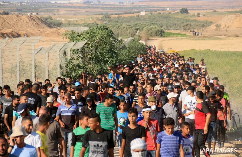 Palestinian protesters gather during clashes with Israeli troops in tents protest where Palestinians demand the right to return to their homeland at the Israel-Gaza border, in al-Bureij in the center of Gaza Strip on Aug...