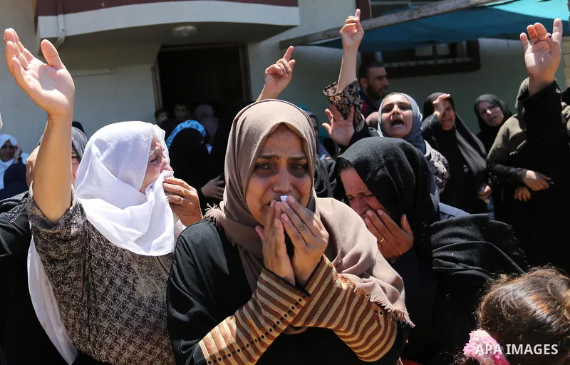Relatives of Palestinian Karim Abu Fatayer, 30, member of the Islamist movement Hamas' military wing Al-Qassam Brigades who was killed by Israeli troops the day before during clashes at Israel-Gaza border, mourn during h...