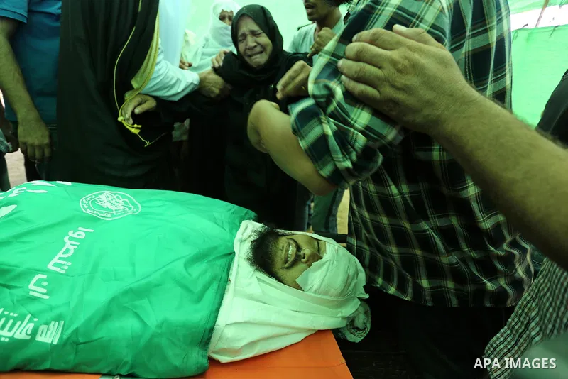Relatives of Palestinian Karim Abu Fatayer, 30, member of the Islamist movement Hamas' military wing Al-Qassam Brigades who was killed by Israeli troops the day before during clashes at Israel-Gaza border, mourn over his...