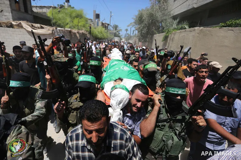 Members of the Islamist movement Hamas' military wing Al-Qassam Brigades carry the body of their comrade Karim Abu Fatayer, 30, who was killed by Israeli troops the day before during clashes at Israel-Gaza border, during...