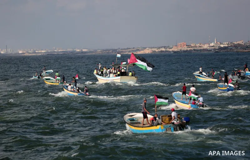 Palestinians ride fishing boats during a rally to break Israel's blockade on Gaza Strip, at the sea in Gaza City, August 18, 2018. Photo by Mahmoud Naser