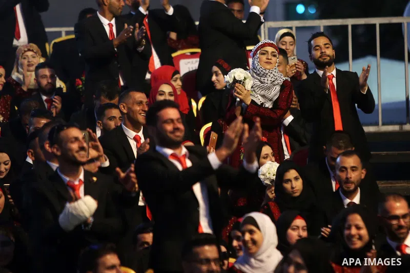 Palestinian couples take part in a mass wedding celebration held under the patronage of Palestinian President Mahmoud Abbas, in the West Bank city of Ramallah on August 18, 2018. Photo by Shadi Hatem