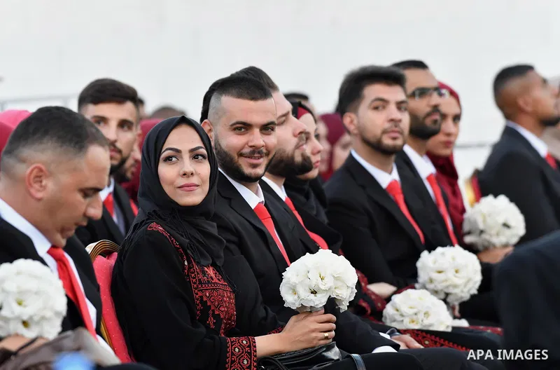 Palestinian couples take part in a mass wedding celebration held under the patronage of Palestinian President Mahmoud Abbas, in the West Bank city of Ramallah on August 18, 2018. Photo by Thaer Ganaim