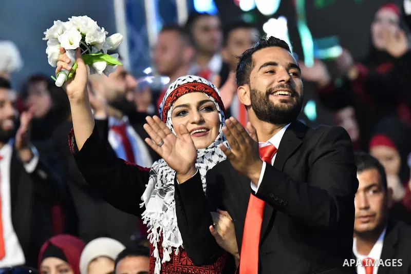 Palestinian couples take part in a mass wedding celebration held under the patronage of Palestinian President Mahmoud Abbas, in the West Bank city of Ramallah on August 18, 2018. Photo by Thaer Ganaim