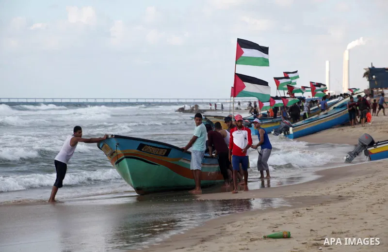 Palestinians ride fishing boats during a rally to break Israel's blockade on Gaza Strip, at the sea in Gaza City, August 18, 2018. Photo by Ramez Habboub