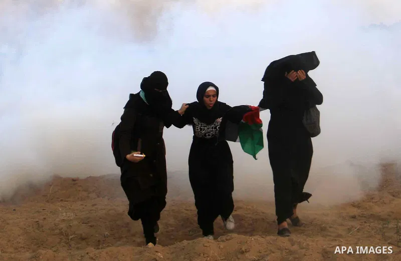Palestinian protesters gather during clashes with Israeli troops in tents protest where Palestinians demand the right to return to their homeland at the Israel-Gaza border, in al-Bureij in the center of Gaza Strip on Aug...