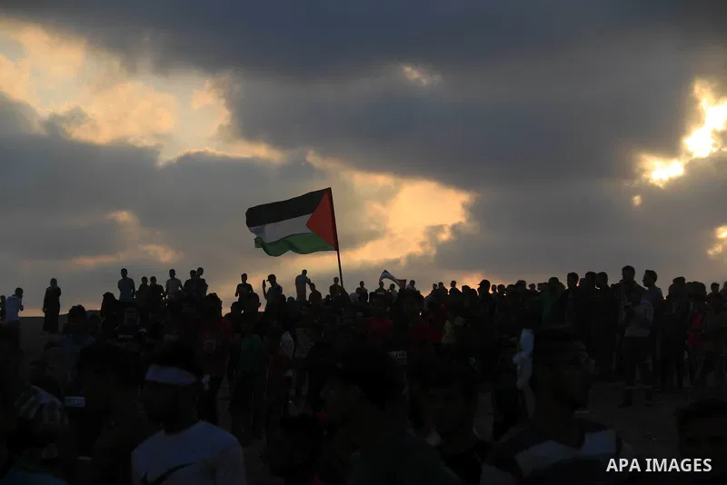 Palestinian protesters gather during clashes with Israeli troops in tents protest where Palestinians demand the right to return to their homeland at the Israel-Gaza border, in al-Bureij in the center of Gaza Strip on Aug...
