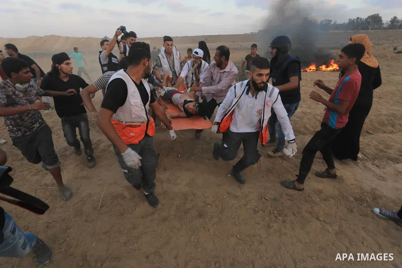 Palestinian protesters gather during clashes with Israeli troops in tents protest where Palestinians demand the right to return to their homeland at the Israel-Gaza border, in al-Bureij in the center of Gaza Strip on Aug...
