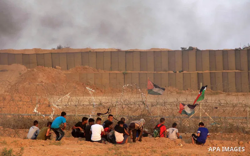 Palestinian protesters gather during clashes with Israeli troops in tents protest where Palestinians demand the right to return to their homeland at the Israel-Gaza border, in al-Bureij in the center of Gaza Strip on Aug...