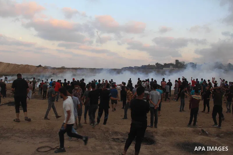 Palestinian protesters gather during clashes with Israeli troops in tents protest where Palestinians demand the right to return to their homeland at the Israel-Gaza border, in al-Bureij in the center of Gaza Strip on Aug...