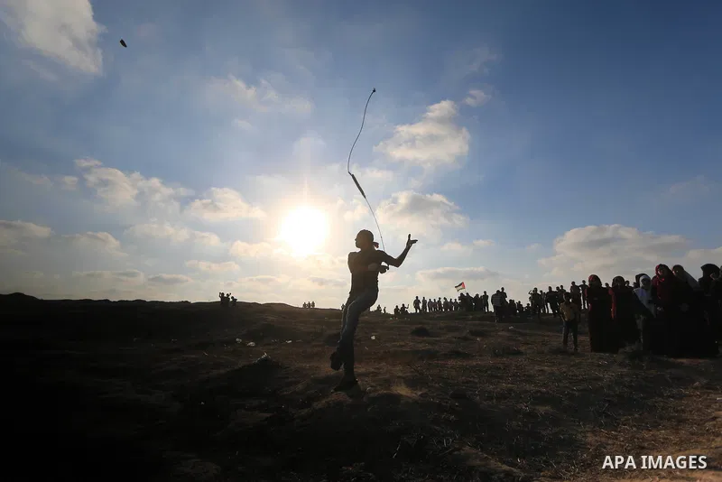 Palestinian protesters gather during clashes with Israeli troops in tents protest where Palestinians demand the right to return to their homeland at the Israel-Gaza border, in al-Bureij in the center of Gaza Strip on Aug...