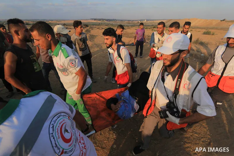 Palestinian protesters gather during clashes with Israeli troops in tents protest where Palestinians demand the right to return to their homeland at the Israel-Gaza border, in al-Bureij in the center of Gaza Strip on Aug...