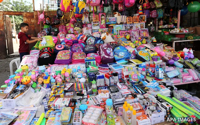 Palestinians shop at a market during preparation for the new school year in Gaza city, on August 26, 2018. Photo by Ashraf Amra