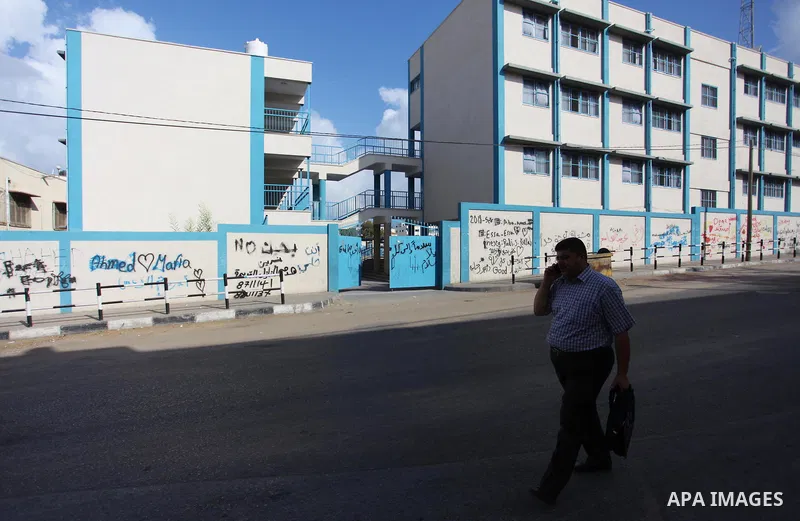 A Palestinian man walks past the school belonging to the United Nations Relief and Works Agency for Palestinian Refugees (UNRWA) a head of the new school year in Gaza city, on August 27, 2018. Photo by Mahmoud Ajour