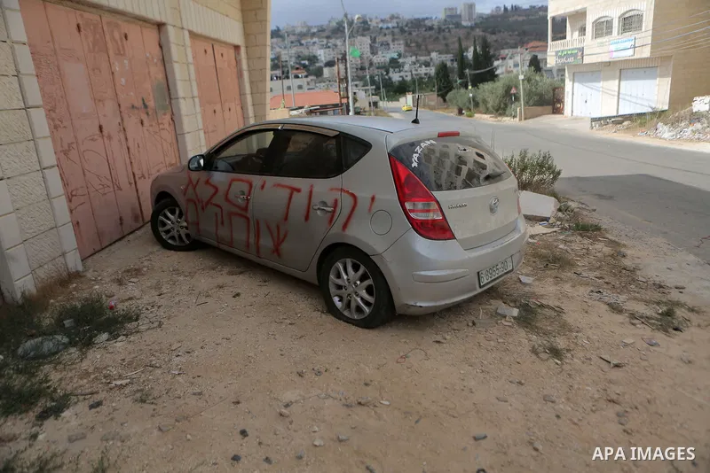 A car is seen after sprayed with racist slogans that read in Hebrew "Jews will not be silent", in the West Bank town of Singel north of Ramallah, on August 27, 2018. Photo by Shadi Hatem