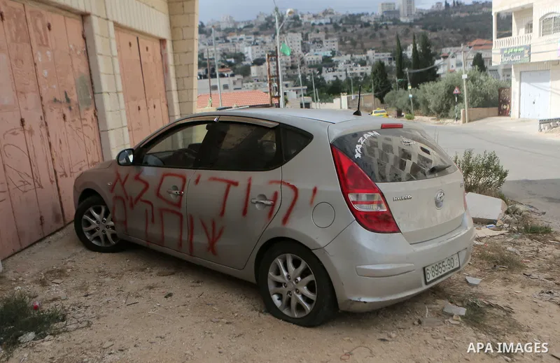 A car is seen after sprayed with racist slogans that read in Hebrew "Jews will not be silent", in the West Bank town of Singel north of Ramallah, on August 27, 2018. Photo by Shadi Hatem