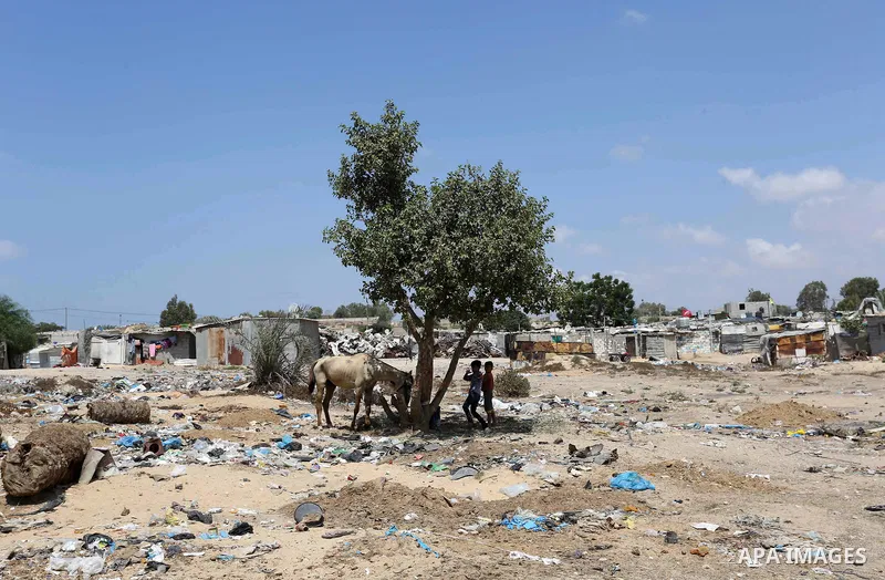 Palestinian children play with a horse in an impoverished neighbourhood of the Khan Younis refugee camp in southern Gaza Strip on August 27, 2018. The United States said that it had cancelled more than two hundred millio...