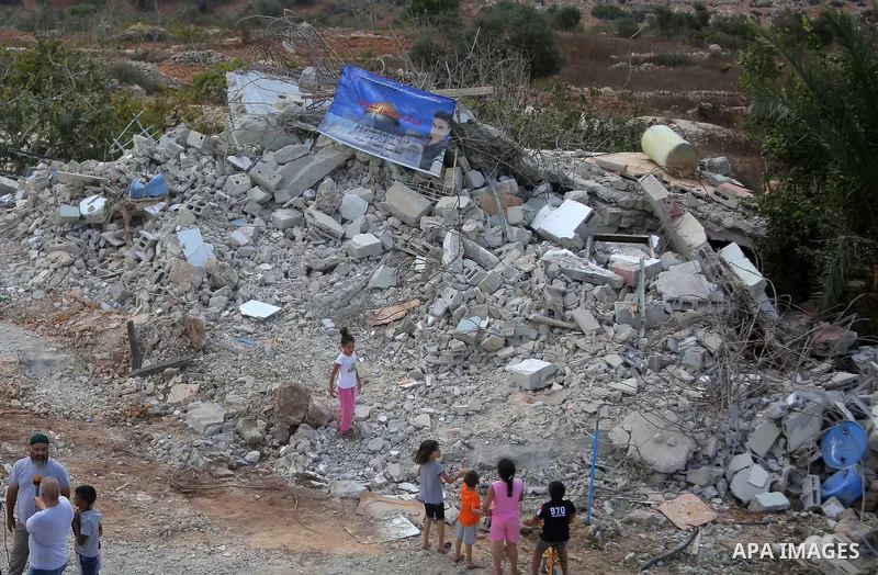 Palestinians stand past the rubble of the house of Mohammed Dar Yousif after it was demolished by Israeli army, in the West Bank village of Kauber near Ramallah, on August 28, 2018. Photo by Shadi Hatem