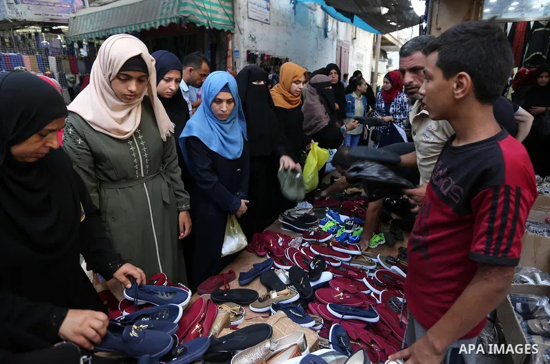 Palestinians shop at a market the day before the start of the new school year, in Khan Younis in the southern of Gaza Strip on August 28, 2018. Photo by Ashraf Amra