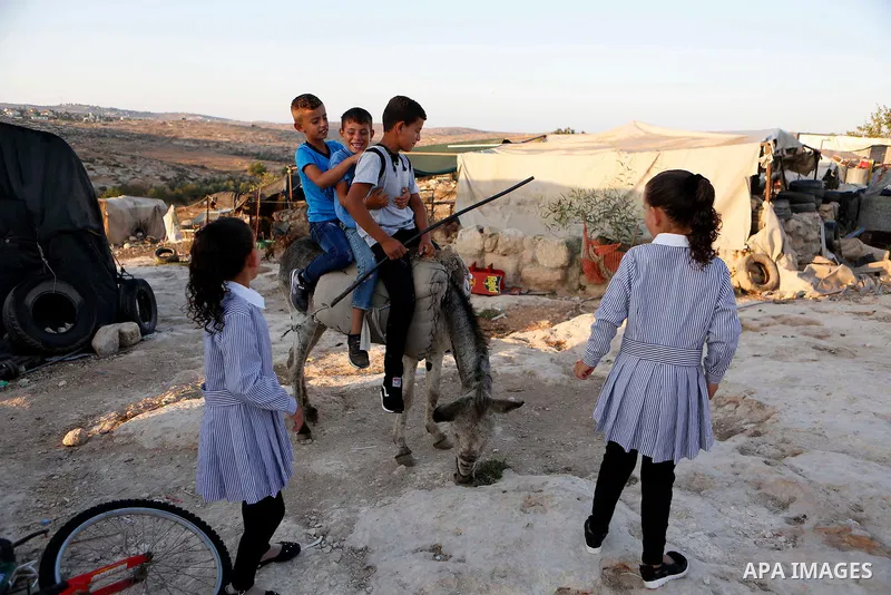 Palestinian schoolchildren return back to their school in the morning of the first day of the new year study, in the village of Susya south of the West Bank city of Hebron on August 29, 2018. Photo by Wisam Hashlamoun