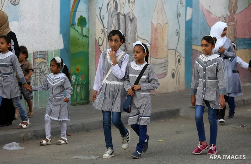 Palestinian students return back to their school in the morning of the first day of the new year study, in Nusseirat refugee camp in the center of Gaza Strip, on August 29, 2018. Photo by Atia Darwish