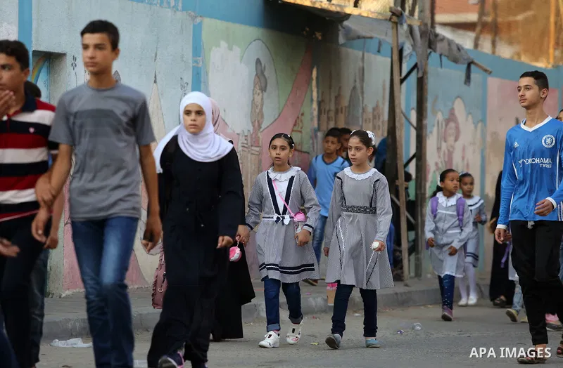 Palestinian students return back to their school in the morning of the first day of the new year study, in Nusseirat refugee camp in the center of Gaza Strip, on August 29, 2018. Photo by Atia Darwish