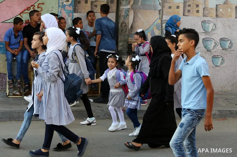 Palestinian students return back to their school in the morning of the first day of the new year study, in Nusseirat refugee camp in the center of Gaza Strip, on August 29, 2018. Photo by Atia Darwish