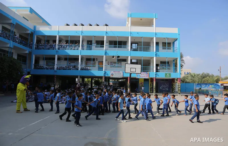 Palestinian students take part in the morning exercise inside their school belonging to the United Nations Relief and Works Agency for Palestinian Refugees (UNRWA) in Deir Al-Balah in the central Gaza Strip, on August 29...