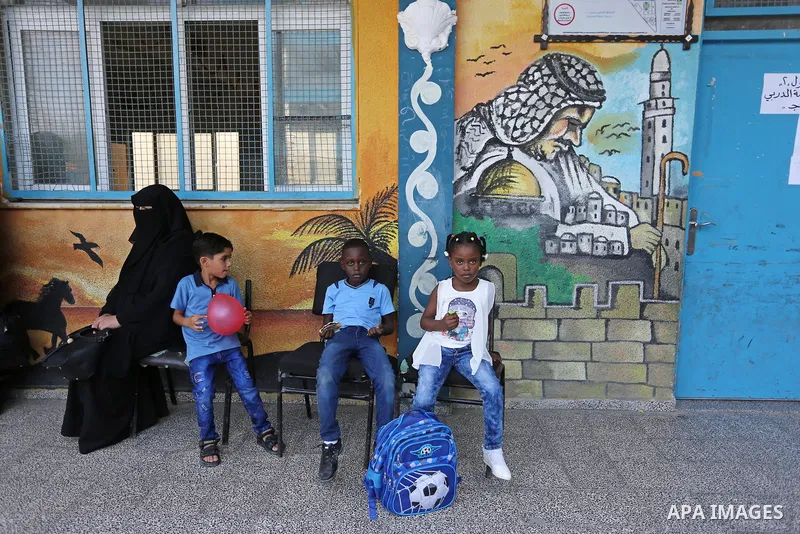 Palestinian students sit outside a classroom at their school belonging to the United Nations Relief and Works Agency for Palestinian Refugees (UNRWA) in Deir Al-Balah in the central Gaza Strip, on August 29, 2018. Photo...