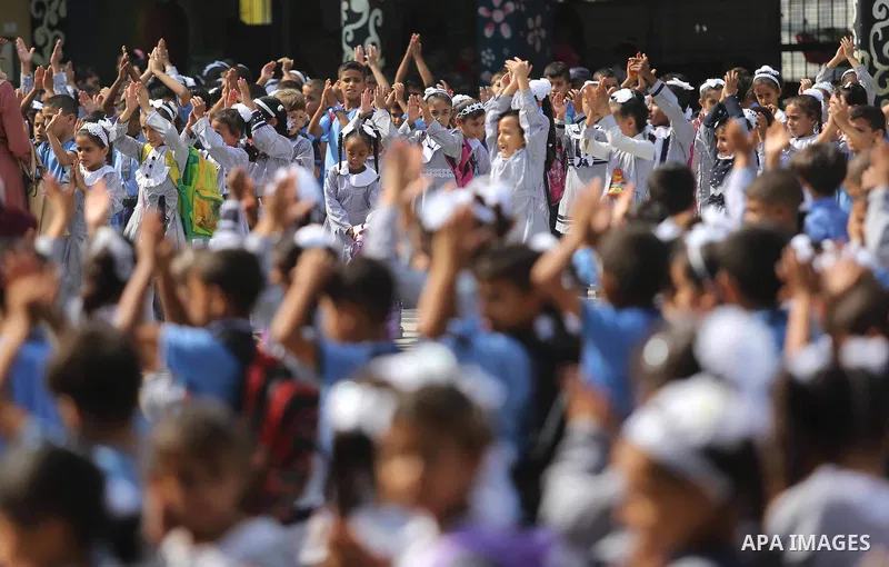 Palestinian students take part in the morning exercise inside their school belonging to the United Nations Relief and Works Agency for Palestinian Refugees (UNRWA) in Deir Al-Balah in the central Gaza Strip, on August 29...