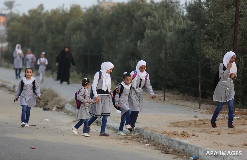 Palestinian students return back to their school in the morning of the first day of the new year study in Deir Al-Balah in the central Gaza Strip, on August 29, 2018. Photo by Ashraf Amra