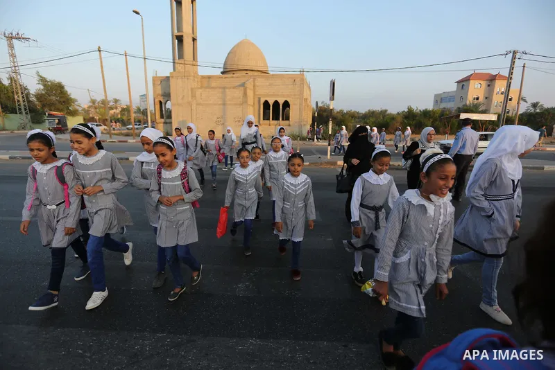 Palestinian students return back to their school in the morning of the first day of the new year study in Deir Al-Balah in the central Gaza Strip, on August 29, 2018. Photo by Ashraf Amra