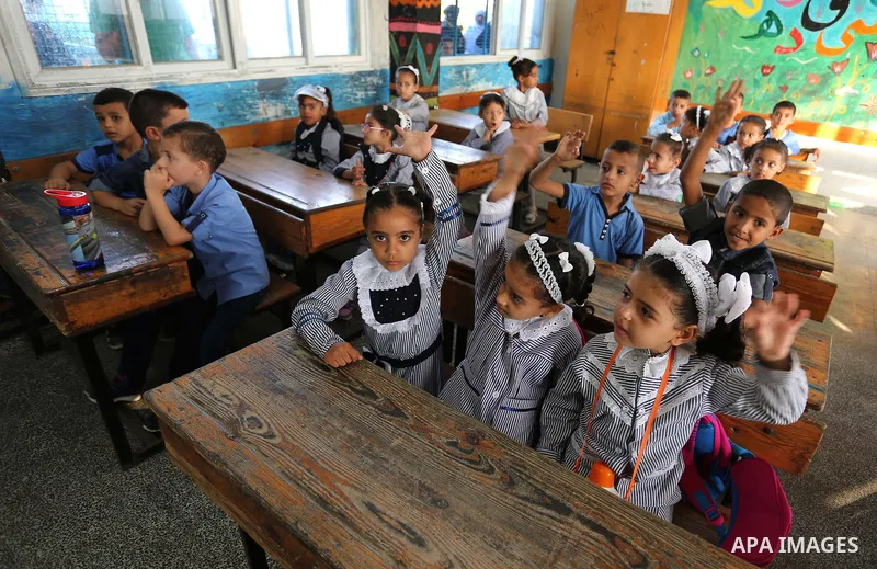 Palestinian students sit inside a classroom at their school belonging to the United Nations Relief and Works Agency for Palestinian Refugees (UNRWA) in Deir Al-Balah in the central Gaza Strip, on August 29, 2018. Photo b...