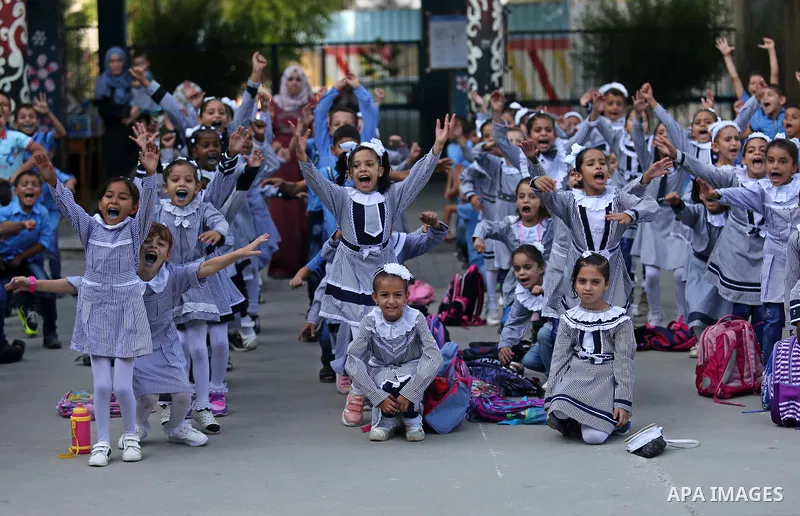 Palestinian students take part in the morning exercise inside their school belonging to the United Nations Relief and Works Agency for Palestinian Refugees (UNRWA) in Deir Al-Balah in the central Gaza Strip, on August 29...