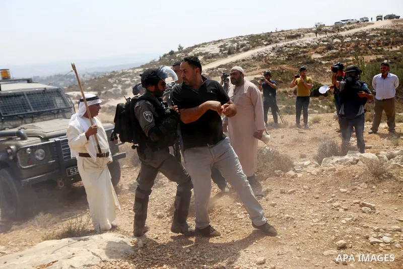A Palestinian protester scuffles with Israeli border policemen during a protest against Israeli settlement construction, in the village of Ras Karkar, near the West Bank city of Ramallah on August 31, 2018. Photo by Shad...