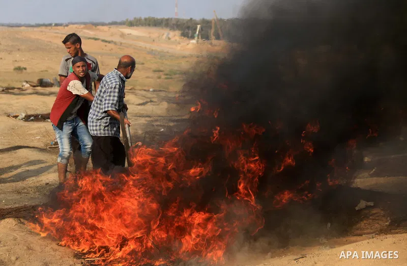 Palestinian protesters gather during clashes with Israeli troops in tents protest where Palestinians demand the right to return to their homeland at the Israel-Gaza border, in al-Bureij in the center of Gaza Strip on Aug...