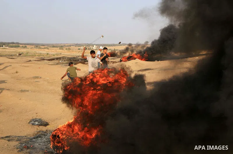 Palestinian protesters gather during clashes with Israeli troops in tents protest where Palestinians demand the right to return to their homeland at the Israel-Gaza border, in al-Bureij in the center of Gaza Strip on Aug...